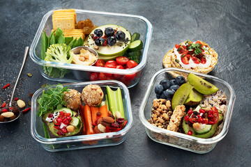 Bbox containing fresh fruits, vegetables, sandwiches, and nuts.