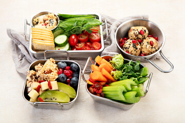Boxes containing fresh fruits, vegetables, sandwiches, and nuts.