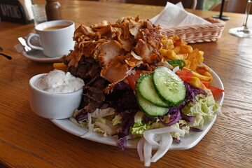Kebab with fries and salad on a plate