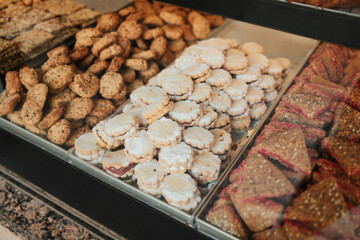 Assortment of cookies and pastries with powdered sugar and seeds in bakery display