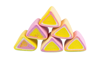 Stacked, triangular, multi-layered candies with yellow centers and pink and white outer layers on a black background