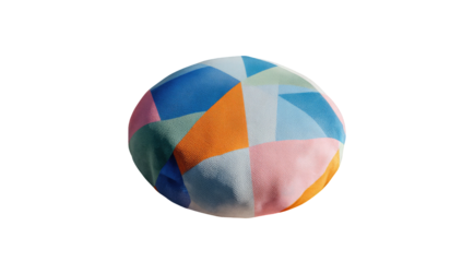 Soft sphere of fabric with colorful geometric patches against black backdrop, with gentle lighting