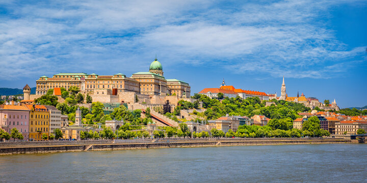 Panoramic view of Buda Castle and Castle Hill in Budapest, Hungary, with Matthias Church above the Danube&mdash;historic terraces and a riverside skyline under a clear summer sky.
