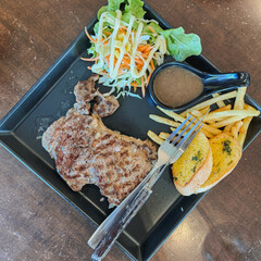 A Deliciously Cooked Steak Accompanied by Sides and a Fresh Salad for a Satisfying Meal