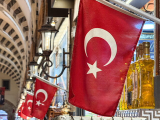Turkish flags hanging above traditional shops inside the Grand Bazaar