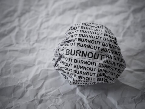 Crumpled paper ball with words Burnout on crumpled white paper background. - Powered by Adobe