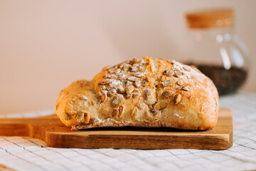 Fresh bread highlighted with watermelon seeds on a wooden board in a cozy kitchen setting
