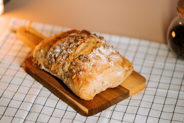Delicious fresh bread baked with watermelon seeds on a wooden cutting board
