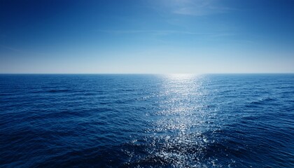 Obraz premium Vast Tranquil Ocean Stretching To The Hazy Horizon Sunlight Glints On The Calm Water A Peaceful Seascape Perfect For Relaxation And Travel Imagery Texture Tranquil