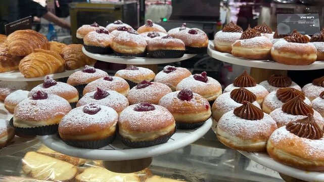 Sufganiyah - Hanukkah doughnuts on display at a coffee shop.  Israeli holiday doughnuts.