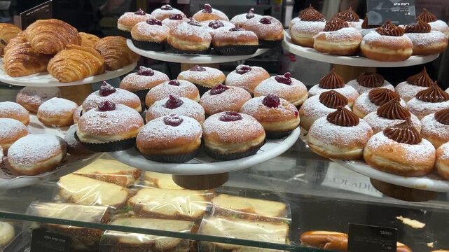 Sufganiyah - Hanukkah doughnuts on display at a coffee shop.  Israeli holiday doughnuts.