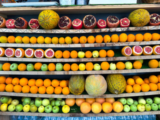 Colorful fruit shop display with oranges, pomegranates, apples, and melons in Istanbul. Traditional Turkish street market offering fresh produce to locals and tourists.