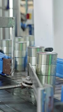 Tomato sauce cans on a conveyor belt in a canned food production facility
