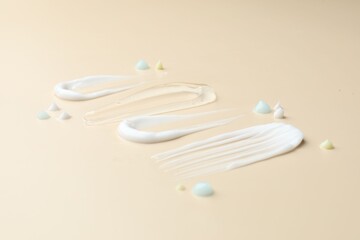 Samples of different cosmetic products on beige background, closeup