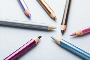 Different eye pencils on light background, closeup