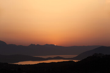 Coffee-brown sunset over the Peloponesse mountains viewed from Poros island, Greece