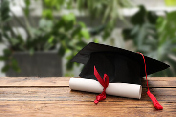 Diploma and graduation hat on wooden table outdoors, closeup. Space for text