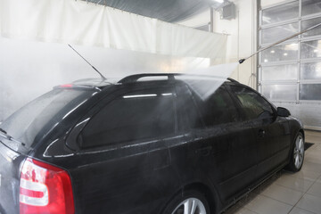 Washing auto with high pressure water jet at car wash, closeup