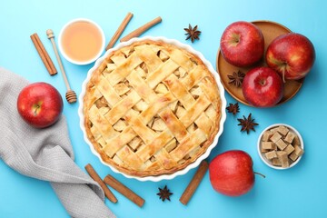 Tasty homemade apple pie and ingredients on light blue background, flat lay
