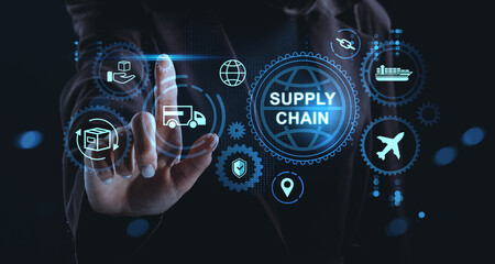 Businessman interacts with digital hologram interface showing supply chain concept icons on dark background with glowing blue elements.