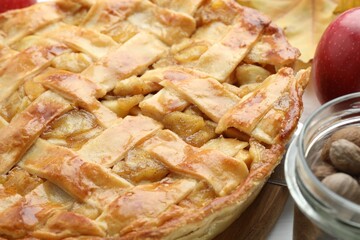 Delicious homemade apple pie and nuts on white table, closeup