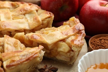 Delicious homemade pie, apples, cinnamon powder and honey on table, closeup
