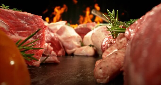 Raw Pile of Various Kind of Meat. Filmed on High Speed Cinema Camera. Meat Preparation Concept, Fire on Background. Camera Placed on Motion Control System.