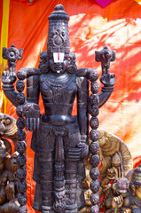 Wooden art, Handmade wooden idol on lord tirupati at surajkund craft fair. Selective focus.