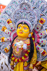 Handmade colorful goddess durga idol souvenir hanging on plain background. Selective focus on object.
