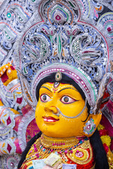 Handmade colorful goddess durga idol souvenir hanging on plain background. Selective focus on object.
