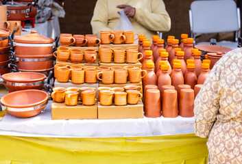 Colorful coffee or tea cups on shelf against ceramic items blur background.
