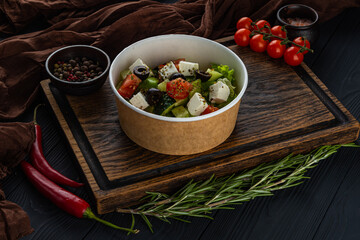 Greek salad in disposable bowl