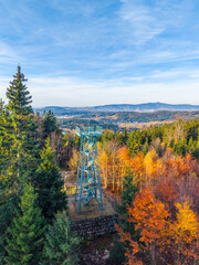 Slovanka Lookout Tower offers stunning views in the Jizera Mountains. Surrounded by vibrant fall foliage, this historic iron tower is a perfect spot for nature lovers. © pyty