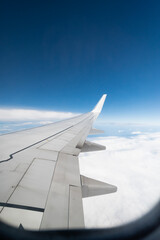 Fototapeta premium view from the window of an airplane in flight on clouds with the wing of a airplane