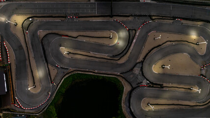 Aerial top view race kart track at night, Track for auto racing top view at night, Car race asphalt and curve street circuit, Aerial view asphalt race track at night.