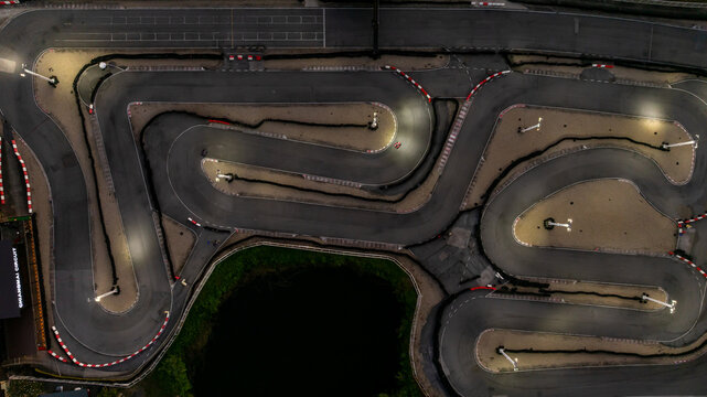 Aerial top view race kart track at night, Track for auto racing top view at night, Car race asphalt and curve street circuit, Aerial view asphalt race track at night.