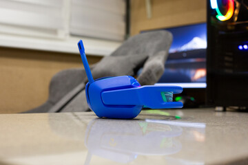 Home gaming essentials. Modern system unit illuminated in various colors, bright headphones and headset against backdrop of gaming chair and monitor. Setup for great evening on gaming computer