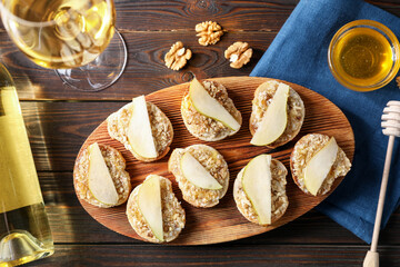 Tasty bruschettas with apples, honey, walnuts and white wine on wooden table, flat lay