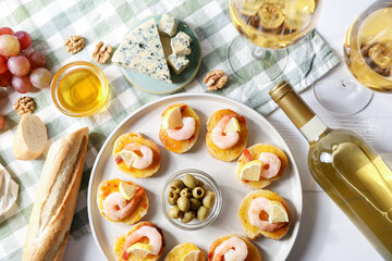 Flat lay composition with tasty bruschettas and wine on white wooden table