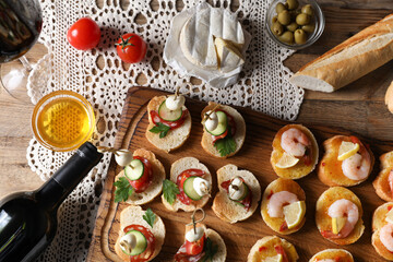 Flat lay composition with tasty bruschettas and red wine on wooden table