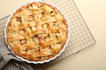 Tasty homemade apple pie on beige background, top view. Space for text