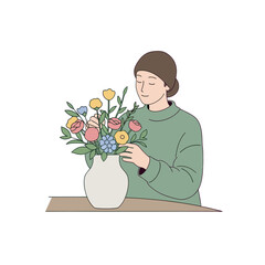Person arranging colorful fresh flowers in vase on wooden table indoors