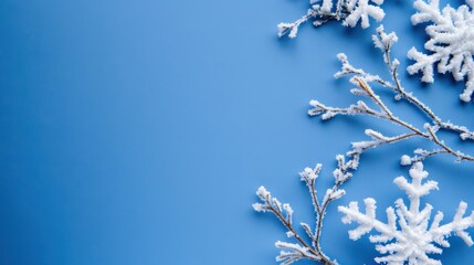 Snowy branches and snowflakes on a bright blue background creating a winter wonderland atmosphere for seasonal themes