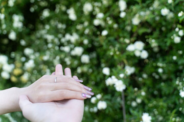 Two hands together among spring flowers②
