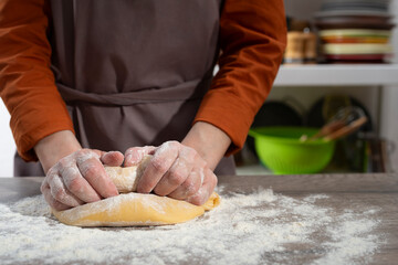 Baking concept. Caucasian female hands kneading the dough.
