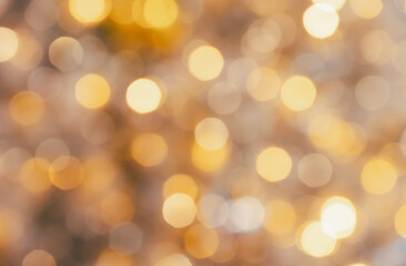 Out of focus golden bokeh circles on warm neutral background for festive holiday celebration abstract