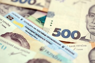 Ukrainian residence permit card or permanent resident card on Ukrainian money close up