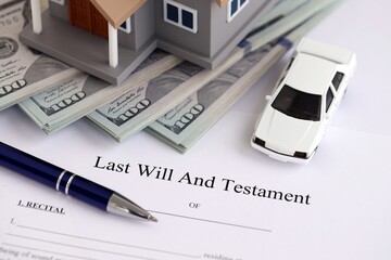 Generic toy house with US dollar bills, car and Last will and testament with pen on table close up