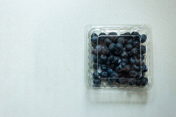 Top view of fresh blueberries in a plastic clamshell container from a supermarket
