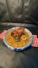Roasted Chicken with Rice and Vegetables Served on Aluminum Plate in Black Background